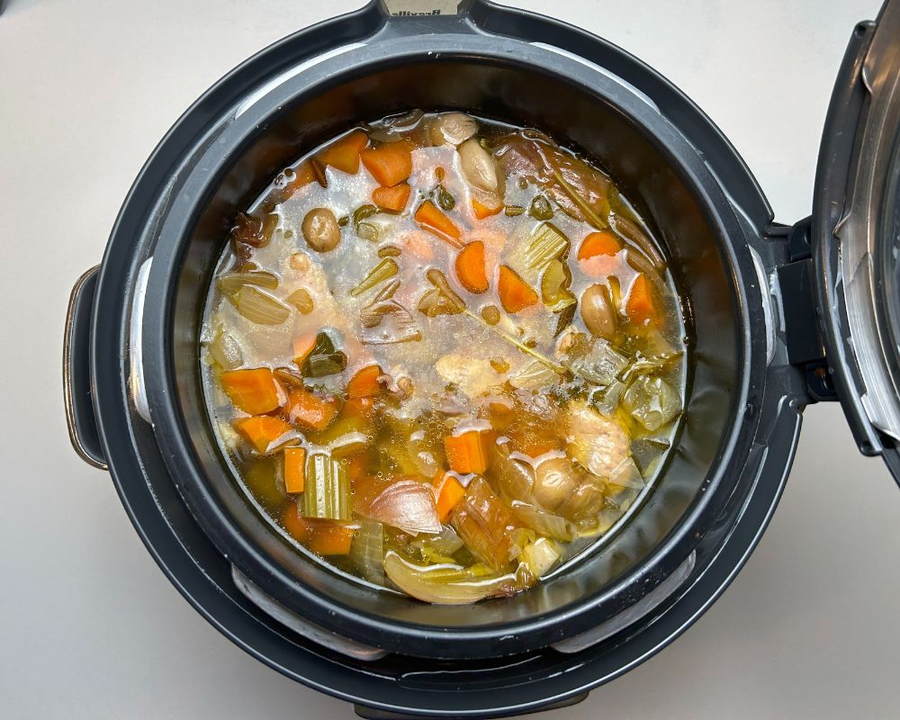 Homemade chicken stock in pressure cooker before straining. 