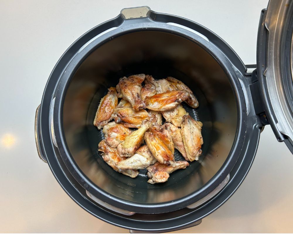 Roasted chicken wings for Homemade Chicken Stock inside of a pressure cooker.