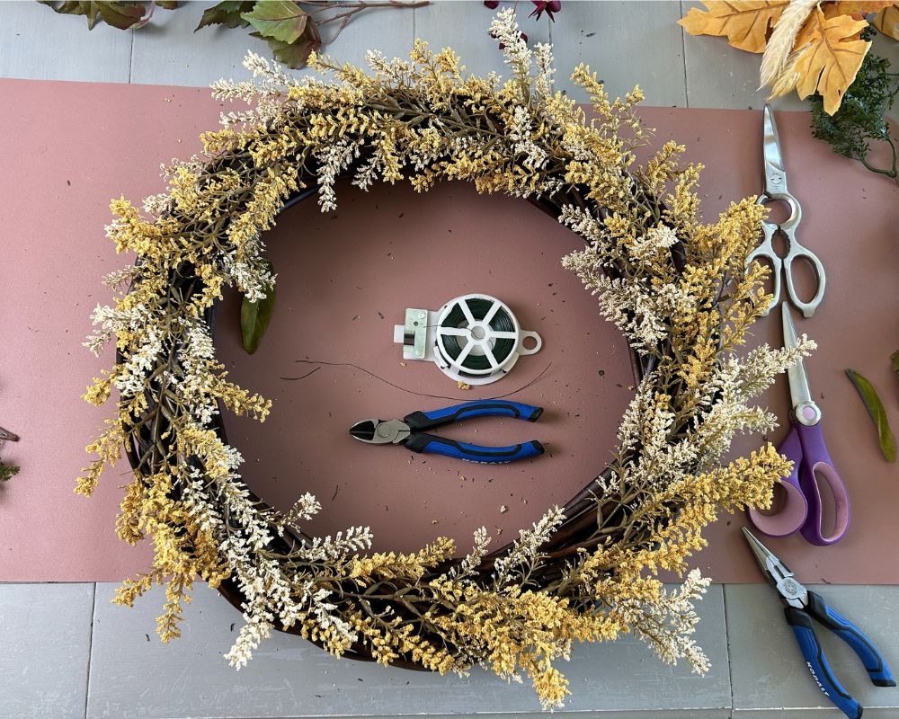 Wreath with yellow and cream floral picks all around.