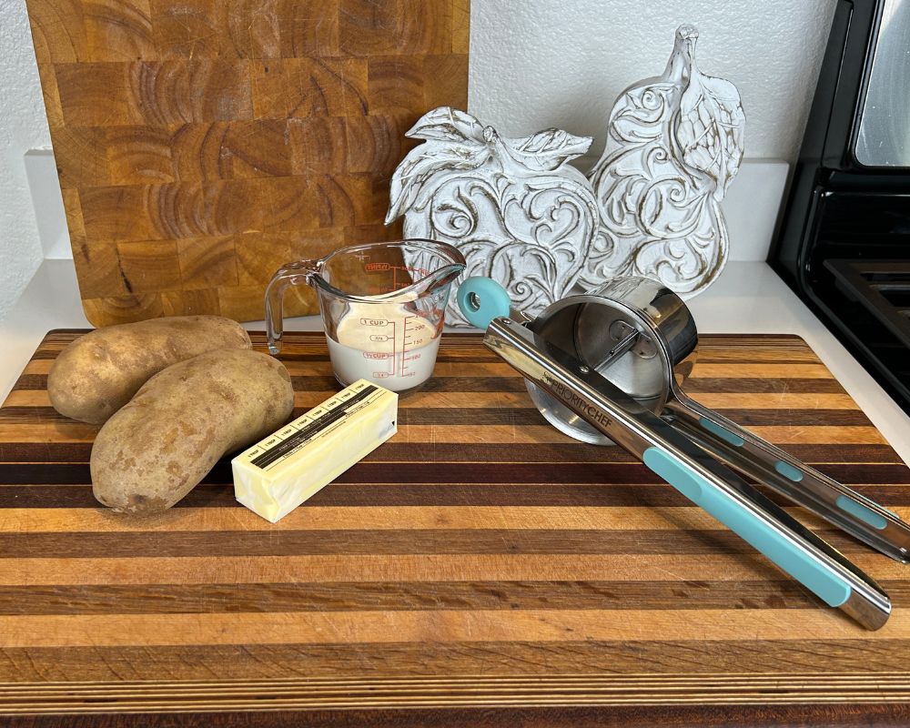 Perfect Mashed Potatoes ingredients on cutting board. Including potatoes, butter and heavy cream. 