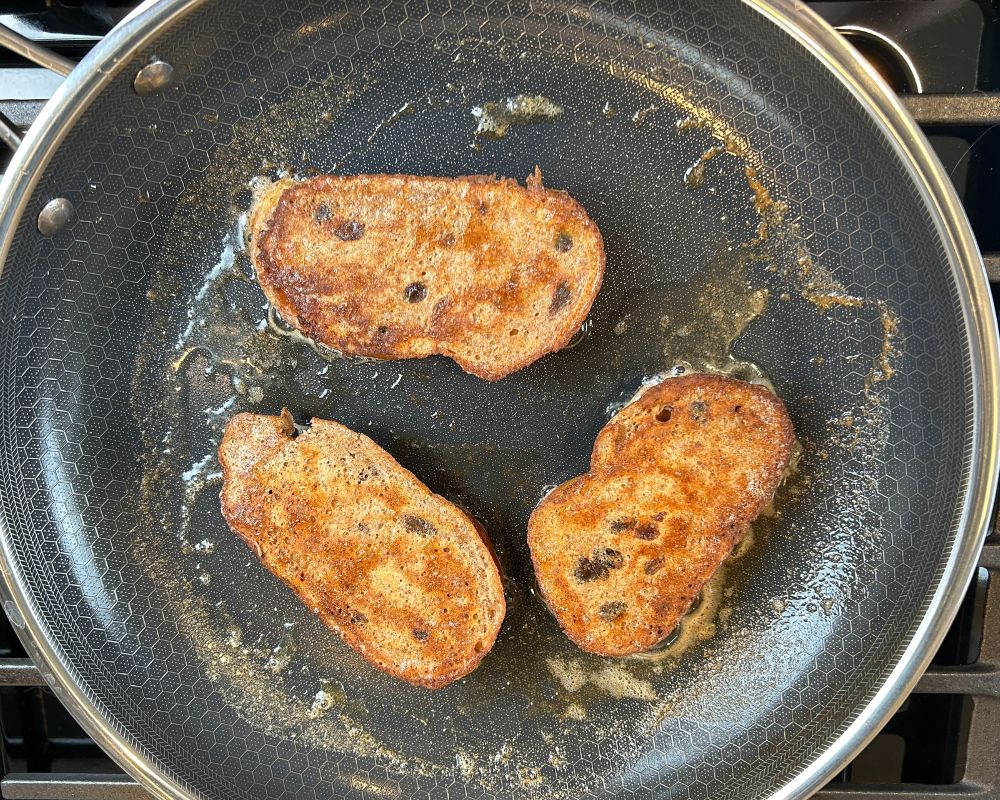 Challah French toast in a fry pan with melted butter.