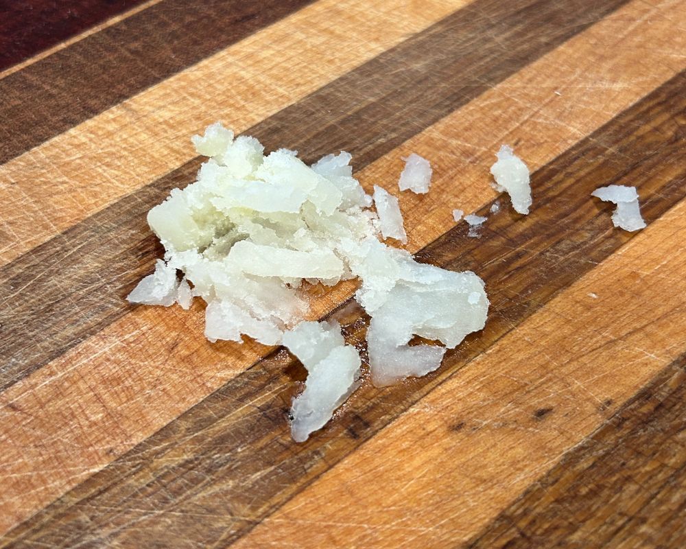 Crushed potato on stripped wood cutting board. 