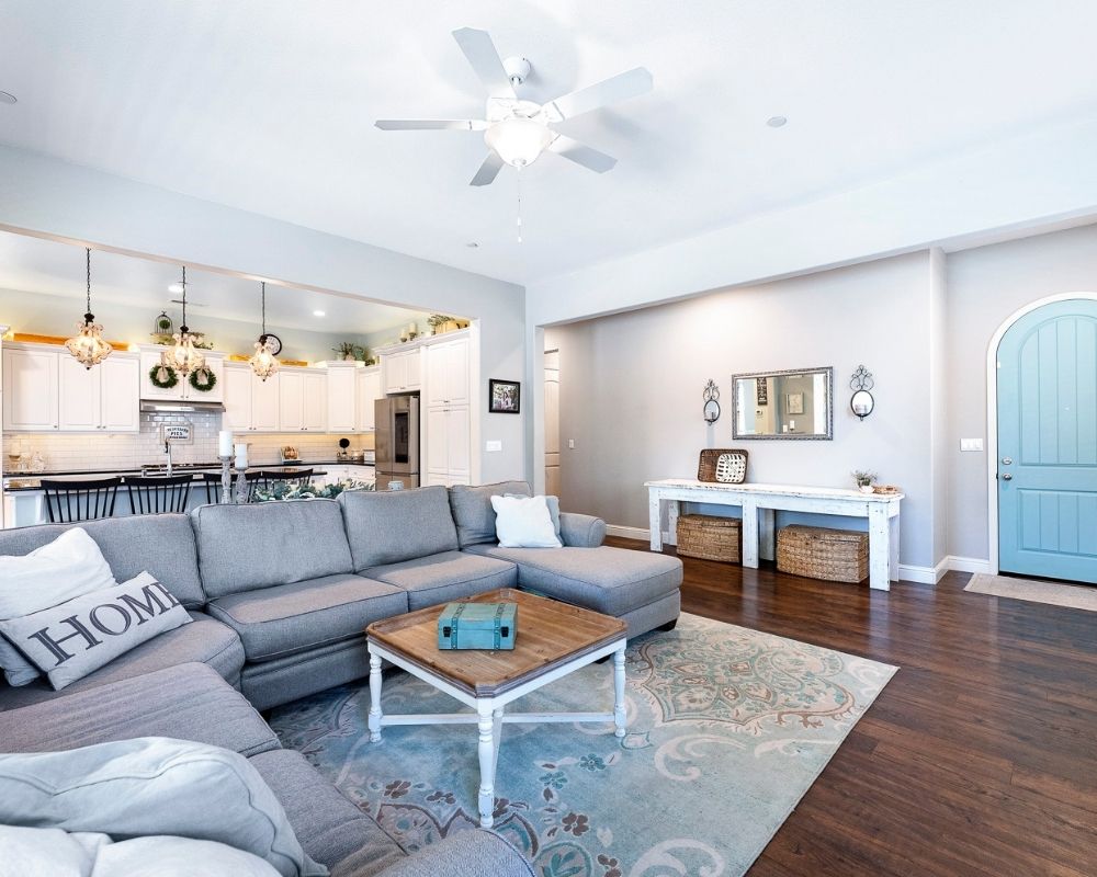 Image of living room with kitchen and hall to bedrooms in the background.