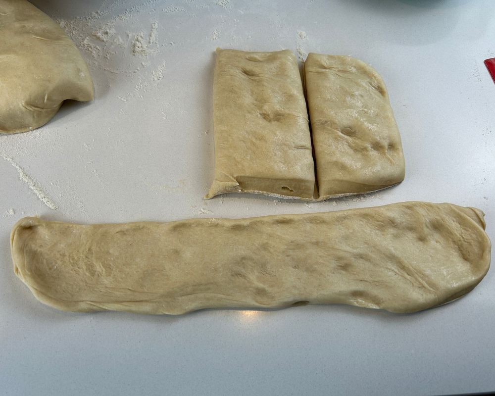 Challah dough flattened and prepared for shaping into strands